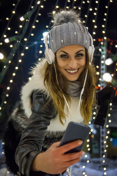 跳舞-女人用自拍手机听音乐和图片图片下载