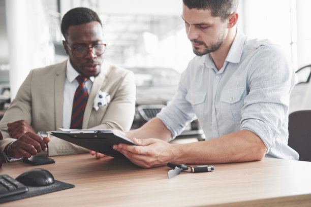 一个年轻漂亮的黑人商人买了一辆新车，他签了一份合同，拿了钥匙去见经理图片下载