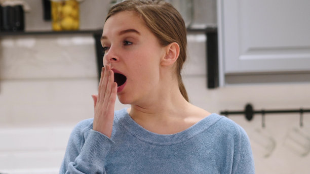 打哈欠疲倦的年轻美丽的女人，室内，家图片下载