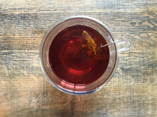 在老木头的背景下，在一杯透明的玻璃杯中注入rooibos图片下载