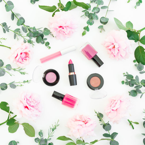 粉色玫瑰花与桉树和化妆品的图案:口红，阴影，白色背景上的睫毛膏。平躺，俯视图图片下载