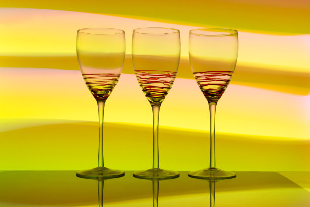 三个带有彩色背景的空酒杯图片下载