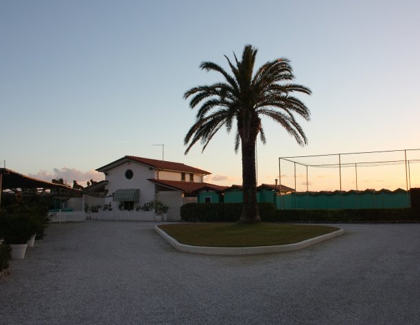 一个封闭的洗浴场所，淡季了。完整的冬天。你可以看到海上的住宅结构，一棵棕榈树，地上的砾石。等待夏天的到来。日落。图片下载