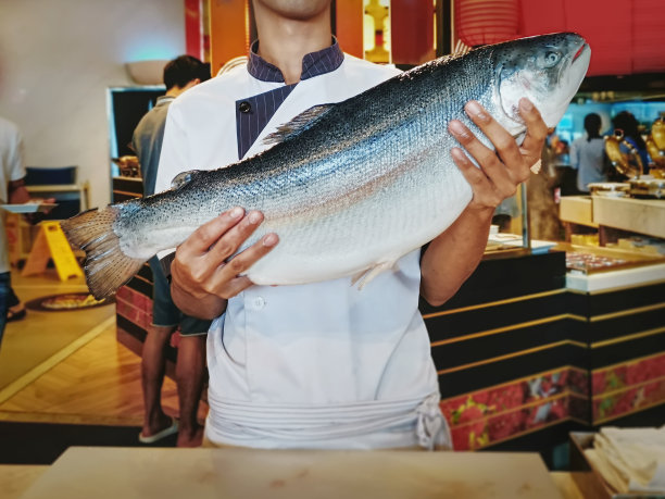 主厨在日式餐厅拿着大鲜鲑鱼图片下载