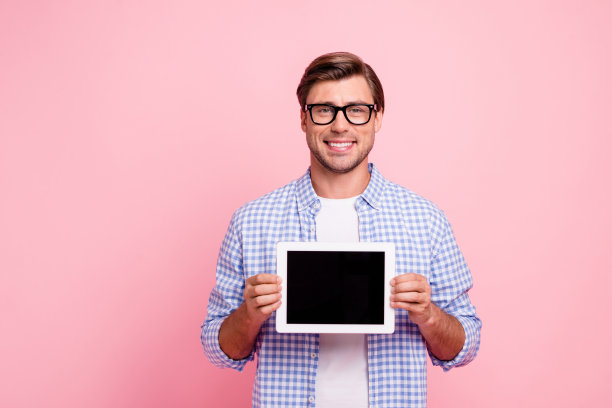近距离的照片美丽惊人的深色他他英俊的手拿电子阅读器在手展示建议穿着眼镜休闲格子衬衫外套孤立在玫瑰背景图片下载