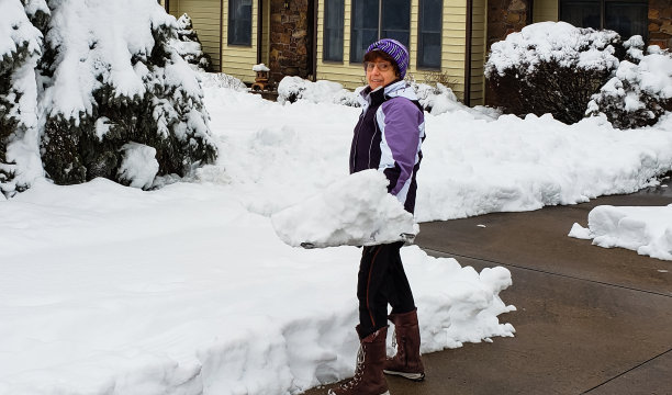 老妇人用铁锹铲雪图片下载