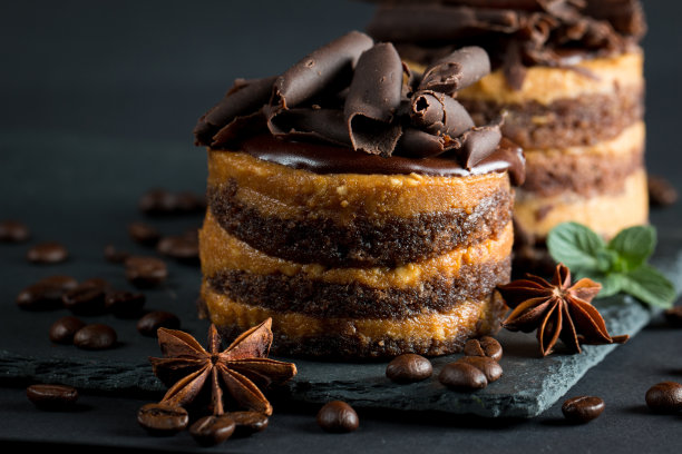 巧克力蛋糕在黑色木板薄荷，咖啡豆在黑暗的背景，特写照片。新鲜、美味的甜品理念。图片下载