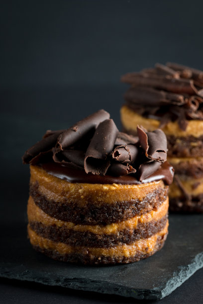 巧克力蛋糕在黑色木板薄荷，咖啡豆在黑暗的背景，特写照片。新鲜、美味的甜品理念。图片下载