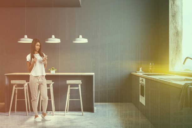 有酒吧和凳子的现代灰色厨房，女人图片下载