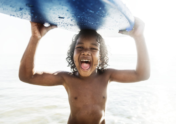 一个带着冲浪板的小男孩图片下载
