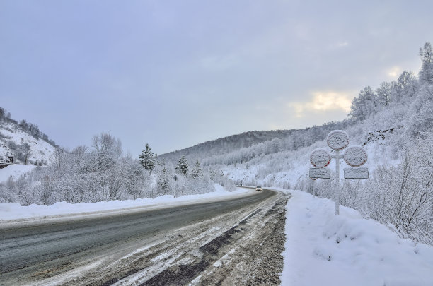 冬季弯弯曲曲的雪山公路穿越山川景观图片下载