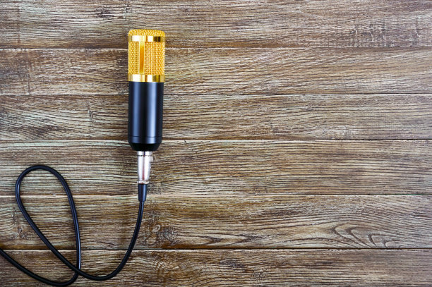 带电缆的冷凝器金色麦克风放在一张有拷贝空间的木桌上。音乐的主题。平的。前视图。图片下载