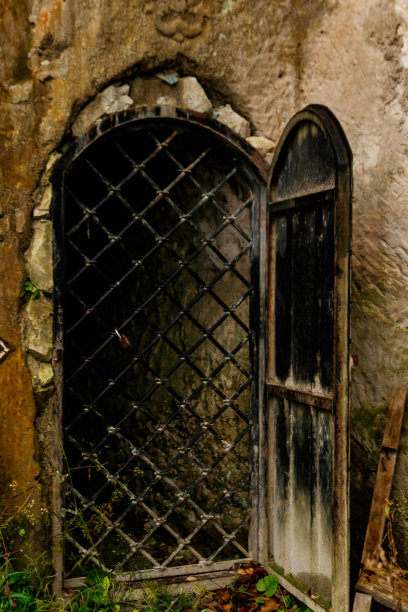 旧石墙门后的铁栅栏图片下载