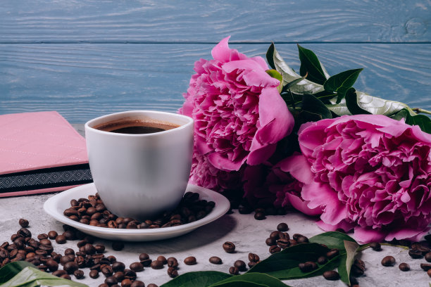 咖啡旁边的桌子上放着带粉色花蕾的牡丹图片下载