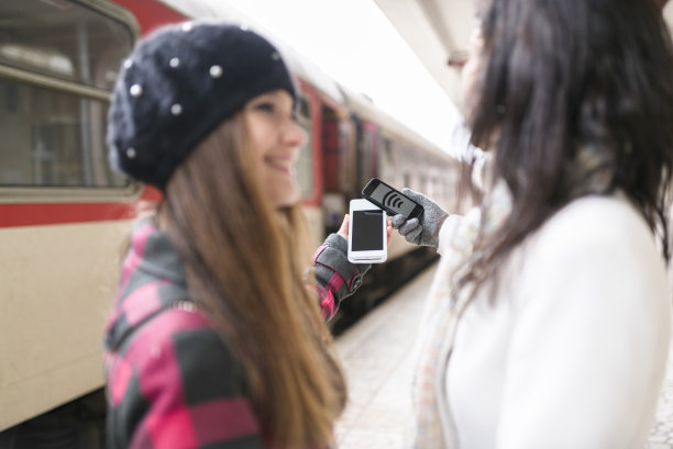 女性旅客在火车站使用手机图片下载