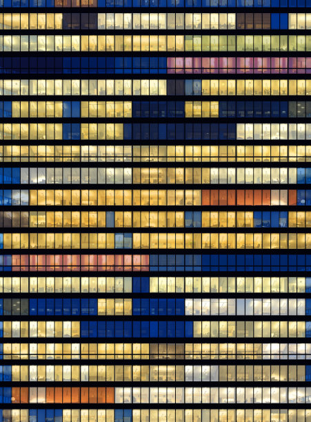 工人工作到很晚。办公室窗户在晚上。图片下载
