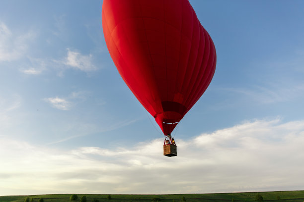 心形的红色热气球在天空中飞翔。爱情、蜜月和浪漫旅行的概念图片下载