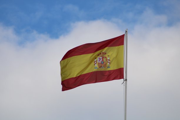 旗杆上的西班牙国旗，在风中摇曳图片下载