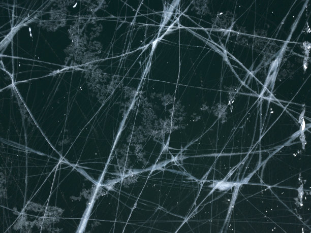 俄罗斯奥尔洪岛冬季结冰的贝加尔湖的航拍照片。深蓝色结冰的湖面上有白色的冰裂缝。图片下载