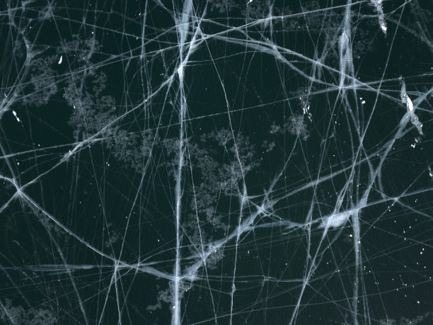 俄罗斯奥尔洪岛冬季结冰的贝加尔湖的航拍照片。深蓝色结冰的湖面上有白色的冰裂缝。图片下载