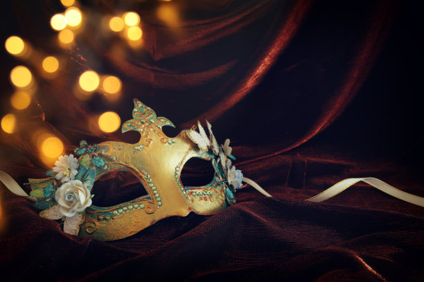照片优雅和精致的金色威尼斯面具在黑暗的天鹅绒和丝绸背景。图片下载