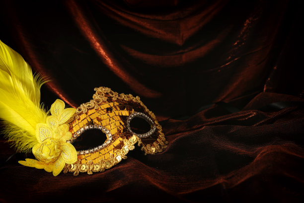 照片优雅和精致的金色威尼斯面具在黑暗的天鹅绒和丝绸背景。图片下载