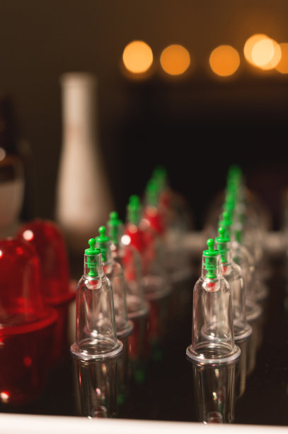 一套医疗玻璃罐和活塞真空按摩在一个黑暗的房间在燃烧的蜡烛图片下载