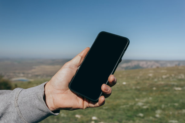 一个男人在户外使用手机的特写图片下载