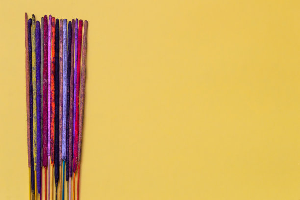 背景的彩色香不同的气味。手工制作的印度香，黄色背景，版权所有。图片下载