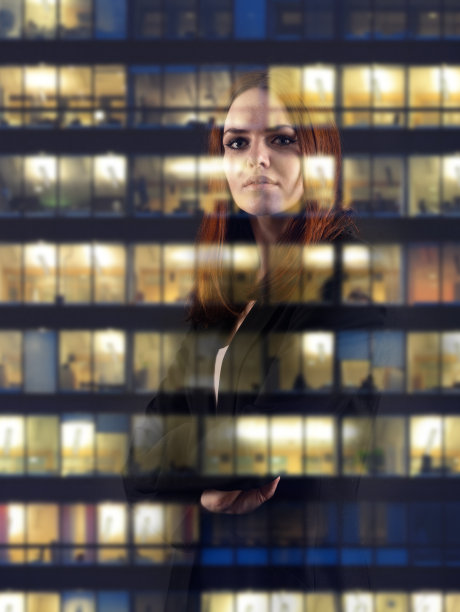 坚定的女商人，双臂交叉，思考，梦想?透过窗户向外看图片下载