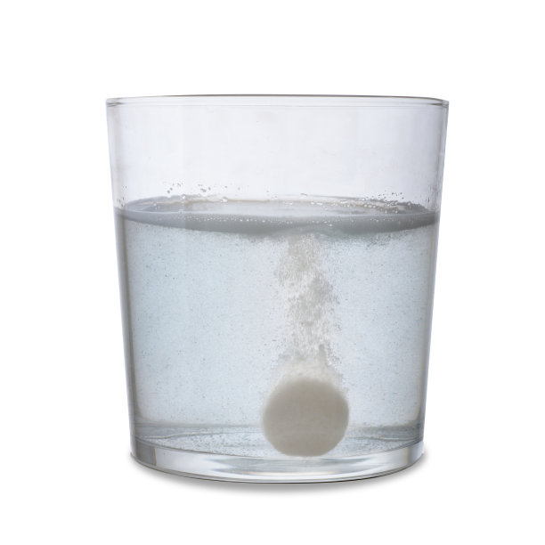 泡腾片，溶于水的玻璃杯中。孤立在白色背景上。图片下载