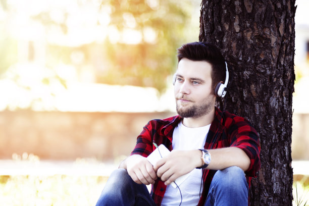 手持数码平板电脑的男子坐在长凳上图片下载