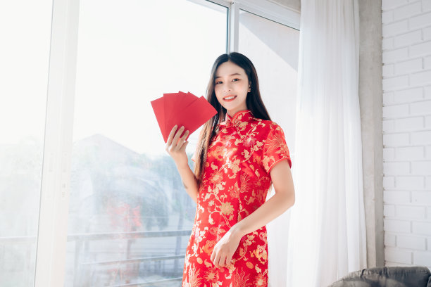 春节亚洲女人肖像身穿旗袍手持红包素材图片