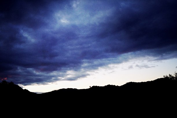乌云聚集在群山之上的地平线上图片下载