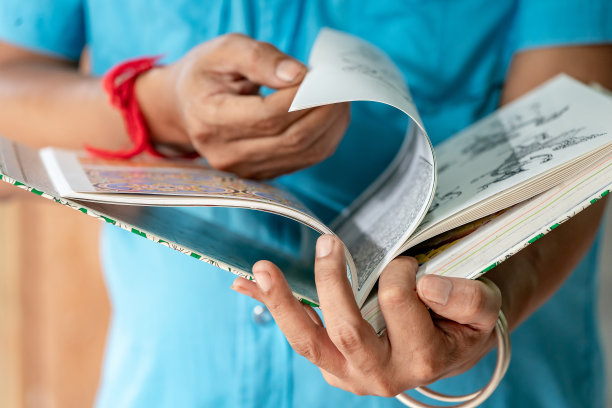 艺术人是持有泰国艺术书籍和寻找他的工作的灵感。图片下载