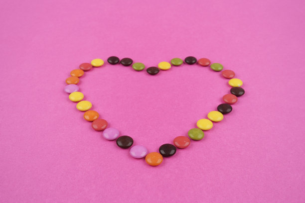 粉色纸上的糖果心。图片下载