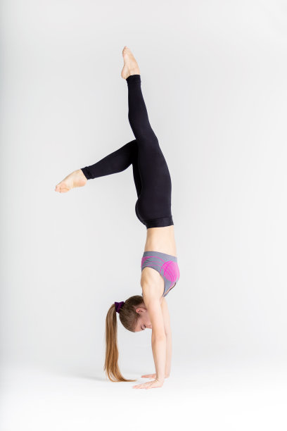 年轻的女运动员在白色的背景上伸展肌肉图片下载