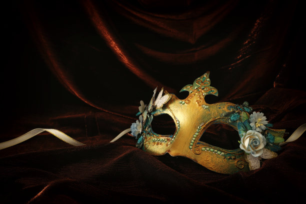 照片优雅和精致的金色威尼斯面具在黑暗的天鹅绒和丝绸背景。图片下载