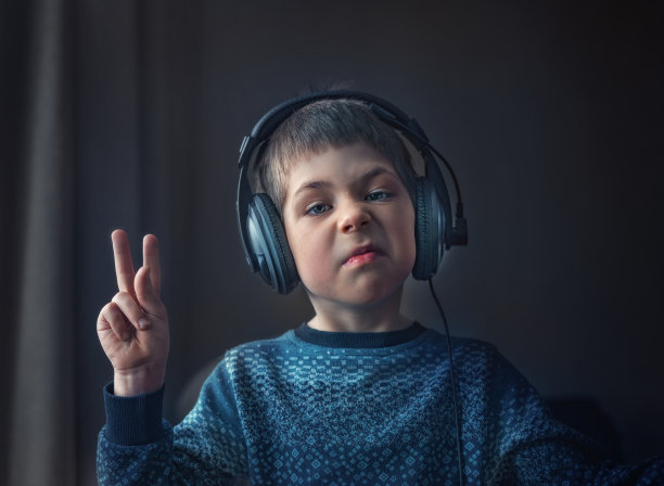 小男孩戴着耳机听音乐图片下载
