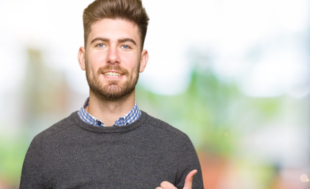 年轻帅气优雅的男子做着快乐的竖起大拇指的手势。赞许的表情看着镜头，表示成功。图片下载