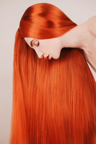 长头发的红发女孩。自然美景。一个有着完美皮肤的年轻女孩的肖像。大量的红头发。在沙龙染发。辉煌的发型。红发美女图片下载