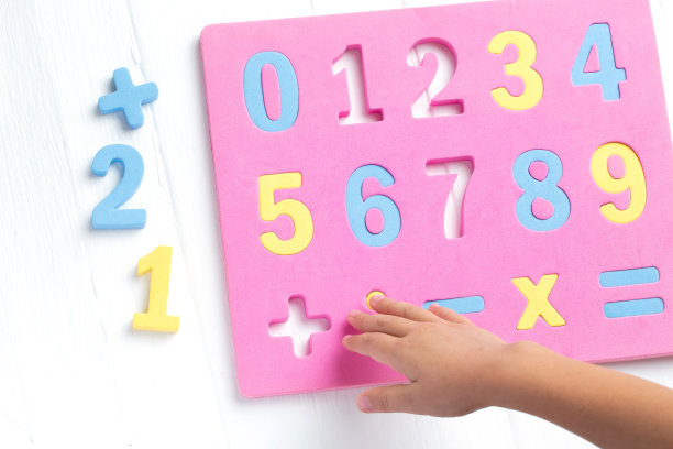 这孩子正在研究数字和账目。将彩色块排列到所需的数字。对儿童数学。图片下载