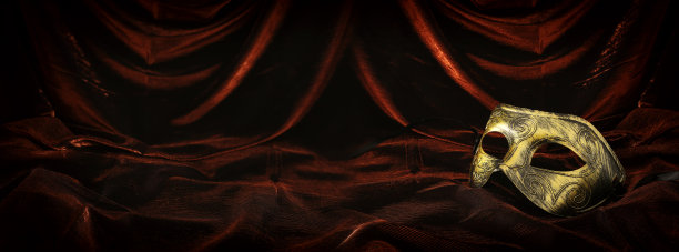 照片优雅和精致的金色威尼斯面具在黑暗的天鹅绒和丝绸背景。图片下载
