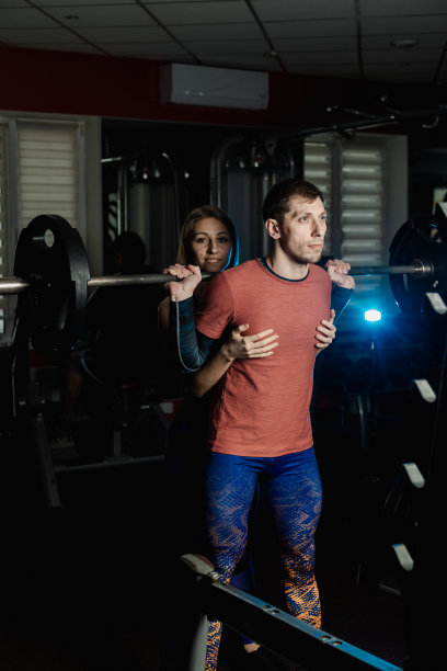 活泼漂亮的健身模特女孩在健身房里坚持蹲着一个运动员图片下载