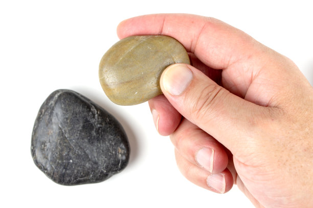 白色背景上的黑色鹅卵石和棕色鹅卵石。图片下载