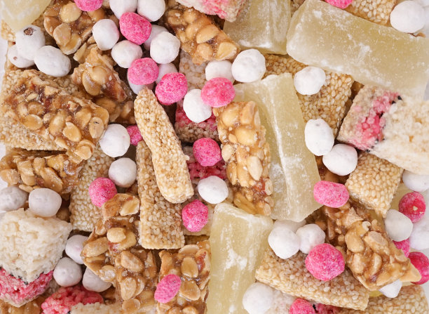 中国的小吃。俯览各种农历新年小吃，包括花生条、芝麻条、甜瓜及农历新年常见的粉白色传统糖果。图片下载