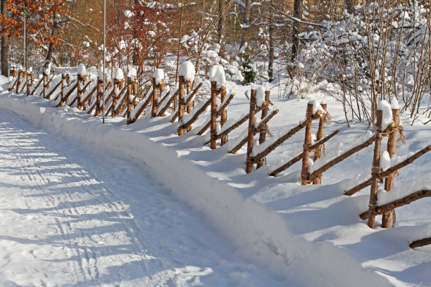 冰雪覆盖的木制装饰栅栏在冬季公园图片下载