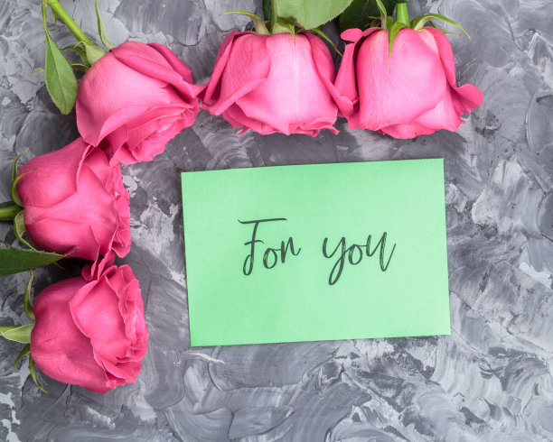 浪漫的概念。红色玫瑰和字母在灰色的混凝土背景上为你图片下载