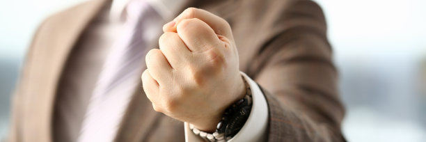 西装男在办公室紧握拳头图片下载