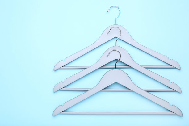 木制的灰色衣架上的蓝色背景图片下载